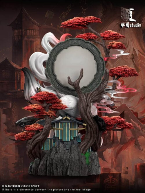 Rear view of the Hsin statue showing the circular backdrop, branching red-leaved trees and teal architectural details above the rocky base.