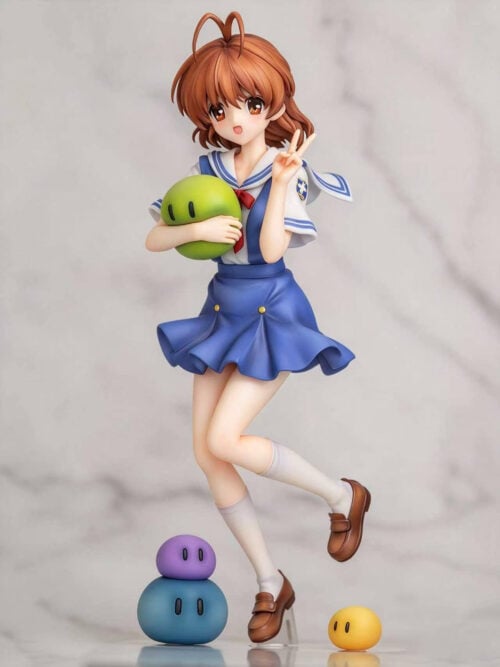 Angled front view of Nagisa Furukawa in a blue-and-white sailor outfit, holding a green mascot with one leg bent behind her.