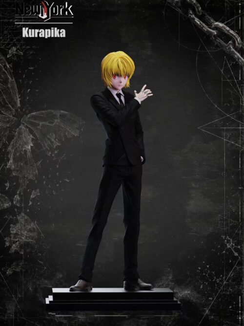 Full-length view of Kurapika in a black double-breasted suit, with his chain-covered right hand raised and left hand in a pocket, on a stepped base.