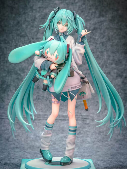 Front view of Hatsune Miku holding a Miku doll, showing her shoulder bag, striped socks, white leg warmers and turquoise shoes.