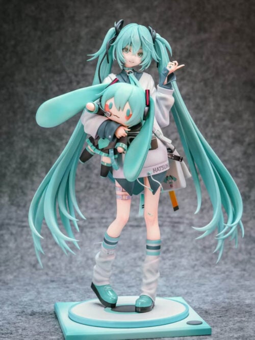 Full front view of Hatsune Miku holding a large Miku doll, with sweeping turquoise twin-tails and a circular platform on a square base.