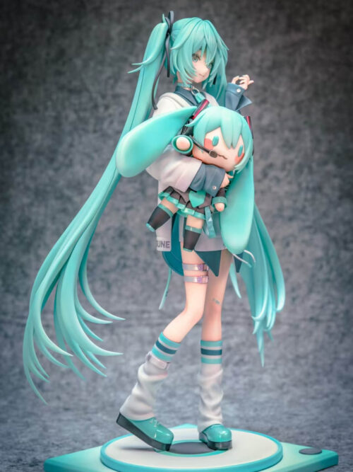 Three-quarter view of Hatsune Miku cradling a headset-wearing Miku doll, with long turquoise twin-tails extending around the standing pose.