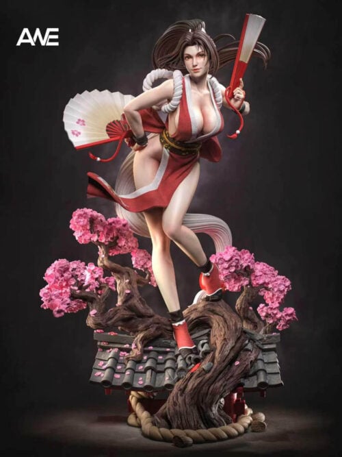 Front view of Mai Shiranui holding two fans above pink flowering branches and a gray tiled rooftop base.