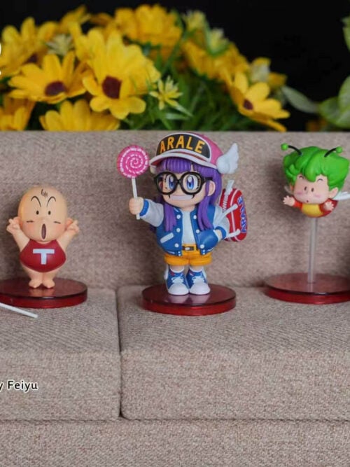 Lollipop Arale on a red base with other figures and pink poop props arranged on a miniature gray sofa.