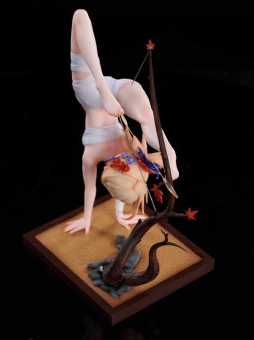 Elevated view of Yoimiya's handstand archery statue with a tree-like bow, rocks and a woven-mat-textured rectangular base.