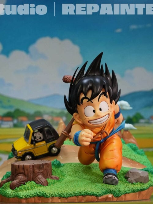 Young Son Goku running beside a tree stump and rock, with a yellow car and miniature mountains on the grassy base.