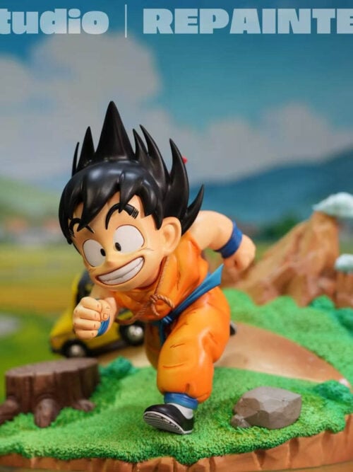Angled view of smiling young Son Goku running across a grassy base with a stump, rock, yellow car and mountain peaks.