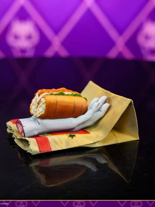 Severed-hand and sandwich accessory resting on a paper-bag-style base, with an inset alternate view.
