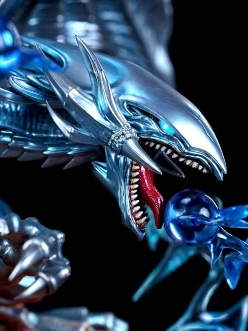Close-up of one Blue-Eyes Ultimate Dragon head with a blue eye, pointed teeth, red tongue and blue energy sphere with jagged effects.