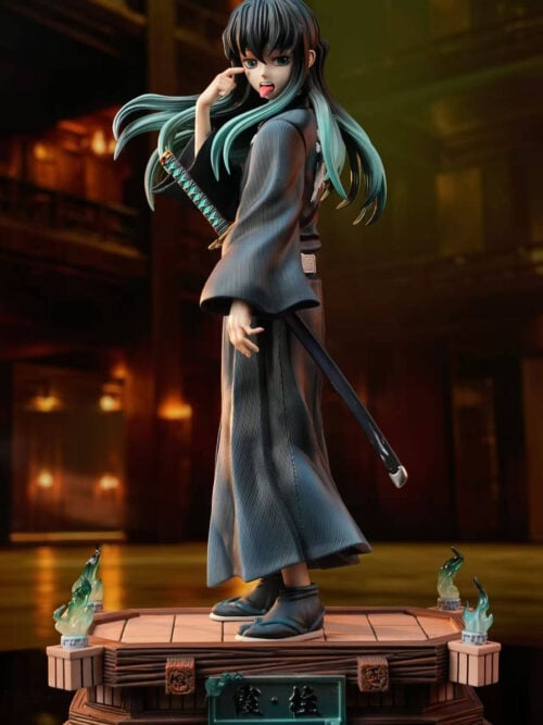 Muichiro Tokito with a tongue-out head and raised hand pointing beneath one eye, shown on the full wood-effect base.