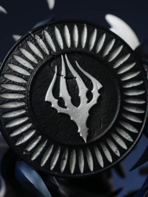 Close-up of the rear circular emblem with a pale central symbol and radial markings between light and dark sculpted effects.