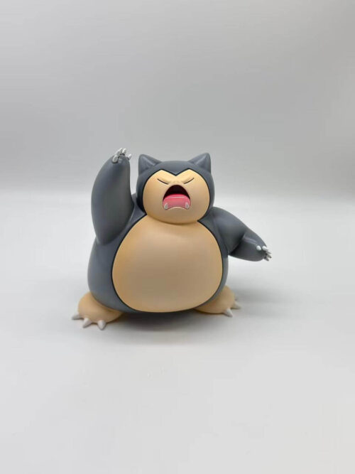 Dark gray Snorlax figure with a cream face and belly, one arm raised and the other extended outward.