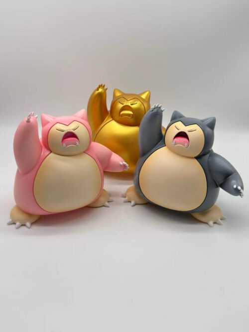 Three Snorlax color versions grouped together, with pink at left, dark gray at right and gold at the rear.