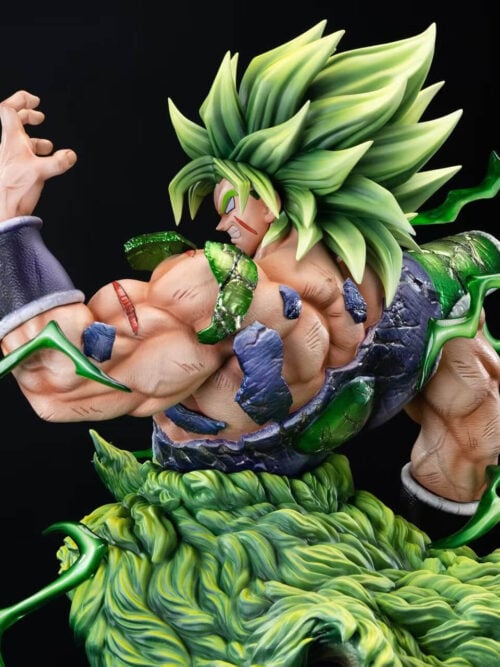 Rear three-quarter detail of green-haired Broly with a raised hand, exposed back, broken armor and green effects around his shoulders.