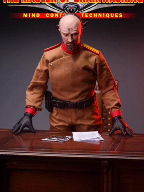 Yuri figure leaning forward with both black-gloved hands on a wooden desk, with papers arranged in front of him.