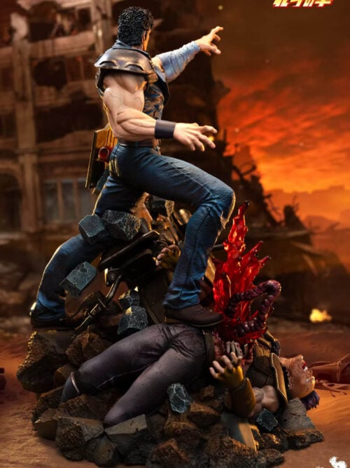 Rear three-quarter view of Kenshiro showing his shoulder armor, wide stance and fallen opponent across the rubble base.