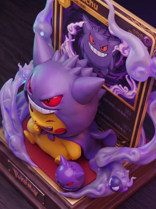 High-angle view of Gengar-costumed Pikachu showing the spiked hood, card backdrop and purple effects around the red-topped base.