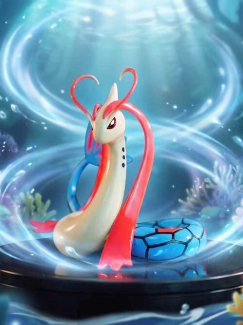 LD Studio Milotic figure with a cream neck, red head fins and coiled blue tail against an illustrated underwater backdrop.
