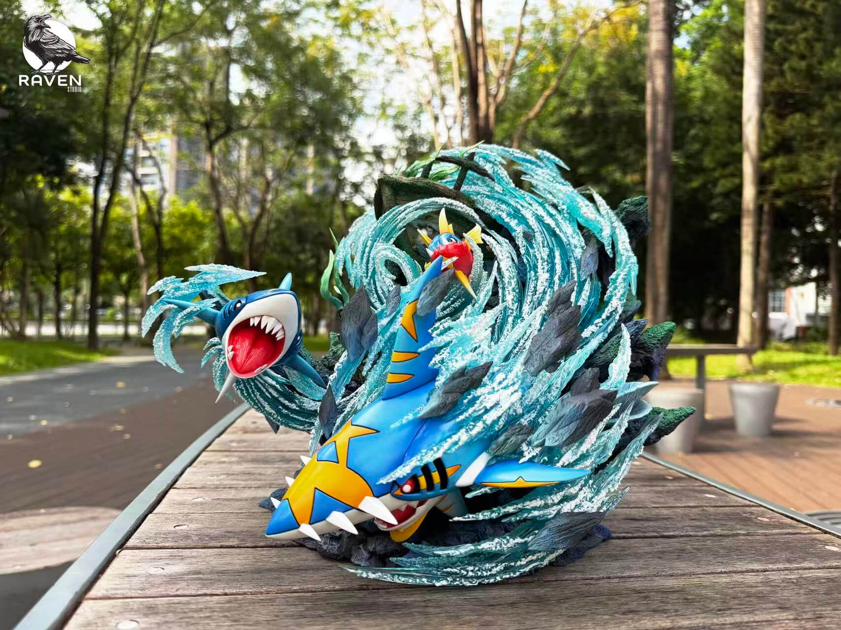 Raven Studio Carvanha, Sharpedo and Mega Sharpedo Diorama — Full View Full view of Carvanha, Sharpedo and Mega Sharpedo surrounded by curling turquoise water effects and jagged rocks.