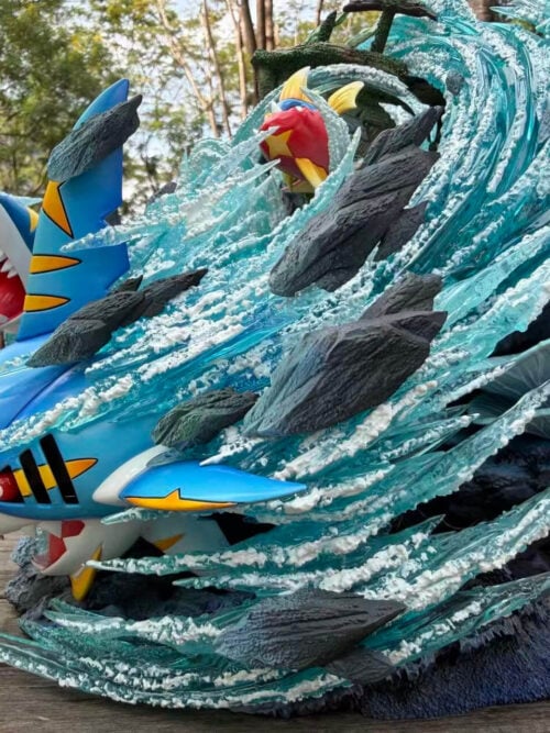 Close side view of Mega Sharpedo's yellow markings and white snout spikes amid turquoise water effects, with Carvanha above.