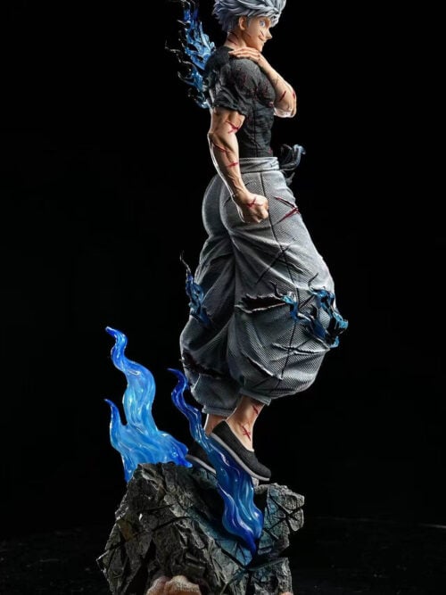 Full view of Satoru Gojo with one hand on his shoulder, torn gray trousers and blue effects above a rocky base.