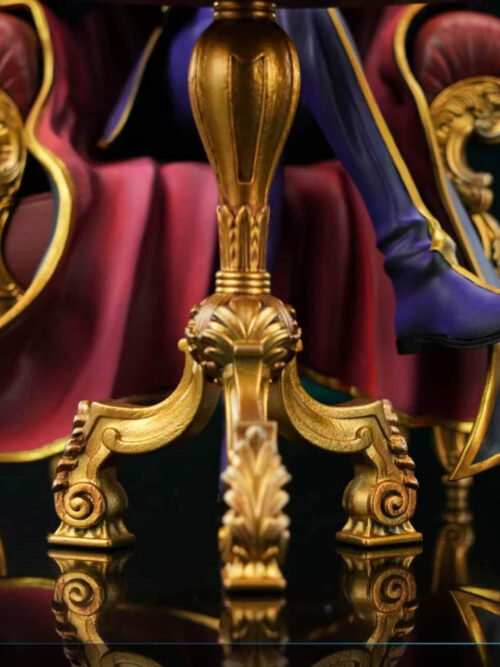 Close-up of the ornate gold tripod pedestal base of the chess table, with Lelouch's red-lined cape and purple gold-tipped boot visible behind it.