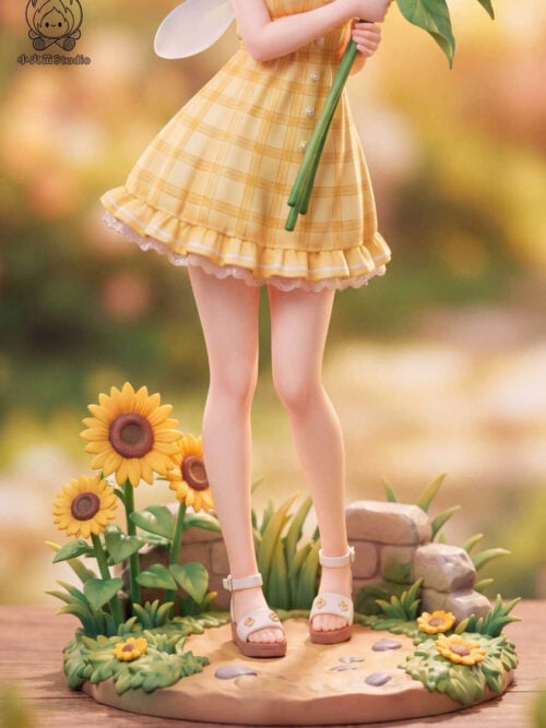Close-up of the lower body and display base of the Mirai Kuriyama figure, highlighting the yellow plaid skirt with ruffled lace hem, white flower-accented sandals, low stacked stones, grass, and blooming sunflowers.