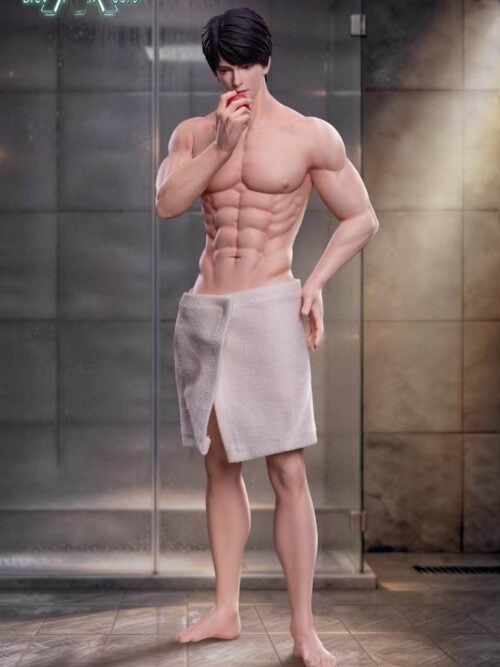 Full-length view of the shirtless Caleb statue in a white bath towel, holding a red apple to his mouth and standing barefoot in a tiled bathroom beside a glass shower.