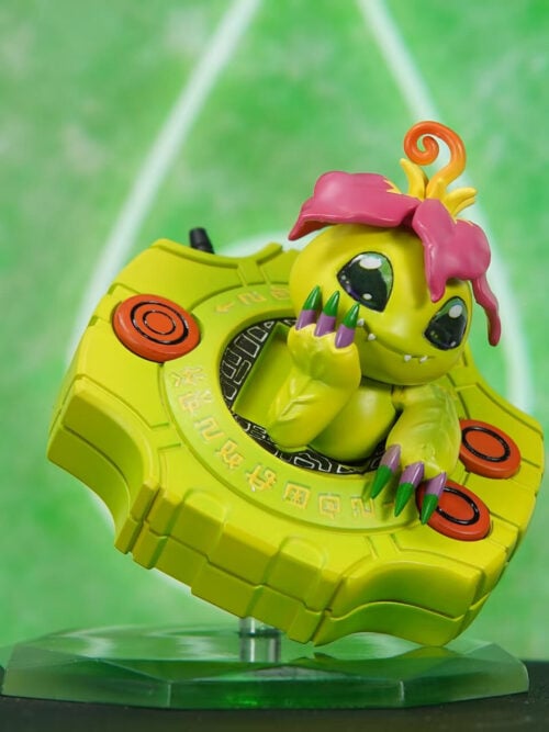 Angled view of the VG Studio Palmon Cute Series figure with Palmon resting one hand on its cheek inside a tilted yellow-green Digivice on a clear green stand.