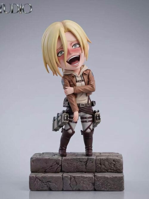 Full front studio view of BA Studio SD-scale Annie Leonhart figure laughing with flushed cheeks, hooded sweater, brown jacket, ODM gear harness, and boots on a two-tiered stone block base