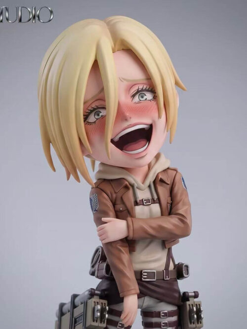 Close-up studio view of BA Studio SD-scale Annie Leonhart figure showing her open-mouthed laughing expression, flushed cheeks, parted blonde hair, and left hand gripping her right forearm