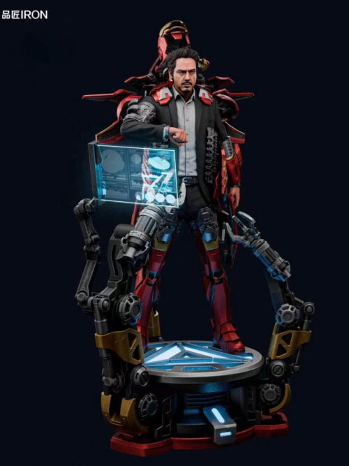 Full front view of IRON Studio's 1/3 scale Iron Man MQ70 Mark VII statue showing Tony Stark in a business suit mid-assembly with open red-and-gold armor panels, a translucent blue data screen, two gantry arms, and a light-up Arc Reactor base.