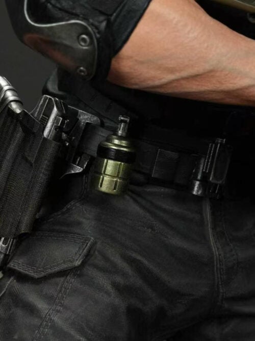 Close-up of Leon Scott Kennedy's right hip and utility belt showing a holstered pistol, a green cylindrical grenade, an elbow pad, and a gloved hand on the rifle.