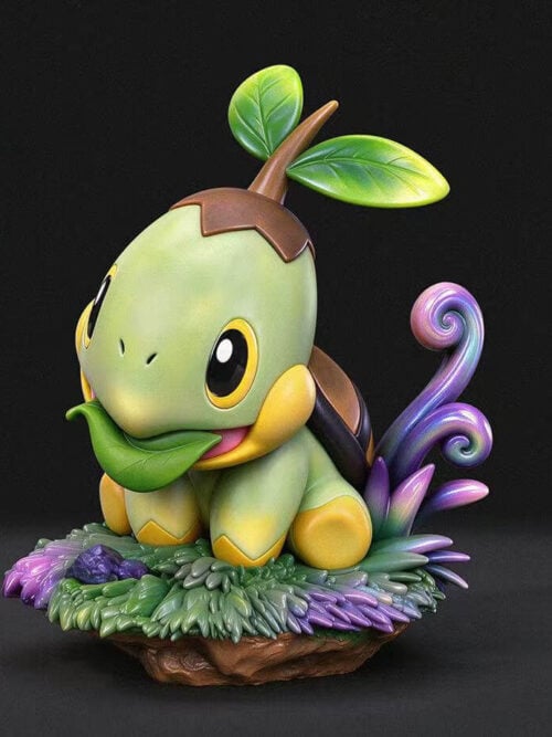 Three-quarter front studio render of the miumiu Studio Turtwig figure seated on a grassy earth base with a folded leaf in its mouth and curling purple-and-blue tendrils behind it.