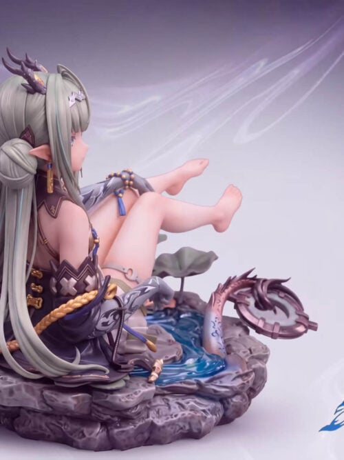 Rear three-quarter view of the Si statue showing her long sage-green hair and twin buns draped over the rocky stream base alongside her raised bare feet and ring-tipped dragon tail.