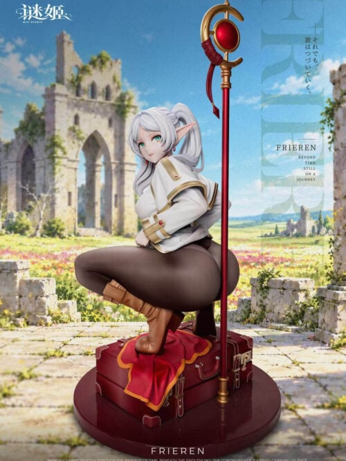 Promotional image of a Frieren collectible crouching on two stacked red suitcases atop a round dark-red base marked FRIEREN. She has silver-white twin-tail hair, pointed ears, a white coat with gold trim, brown leggings and boots, with one boot on a red cloth and a tall red-and-gold staff with a red orb beside her. A ruined stone arch and flower field form the backdrop, with MiJi Studio branding.