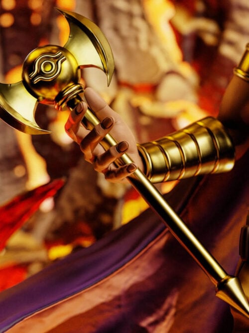 Close-up of Marik Ishtar's right hand and segmented gold bracer gripping the gold scepter with an eye emblem and curved blades