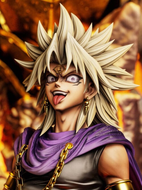 Close-up of Marik Ishtar's head sculpt showing spiky blonde hair, forehead eye symbol, wide purple eyes, grinning mouth with tongue out, gold earrings, and chain-fastened purple cape