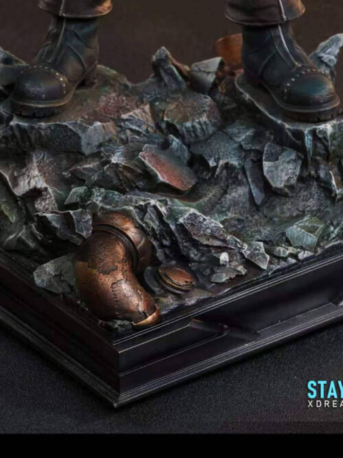 Close-up of the Flagship Version display base showing Cloud Strife boots on rocky rubble with an exposed rusted pipe and black plinth