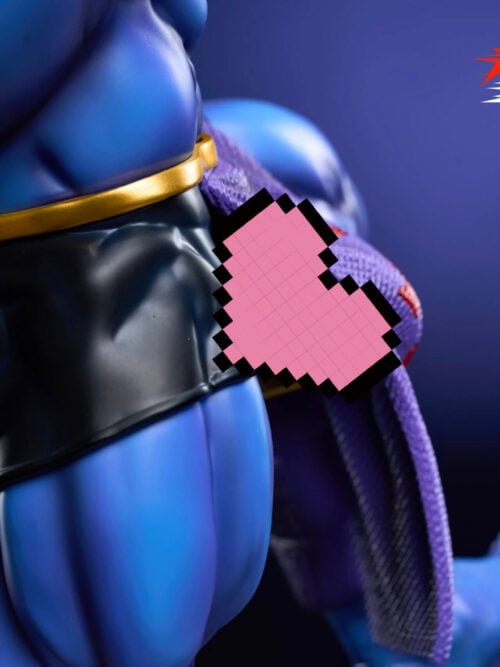 Side close-up of the black shorts, gold belt, hanging purple fabric, and blue thigh, with a bare foot visible in the background. A pink pixelated heart overlays the hip area.