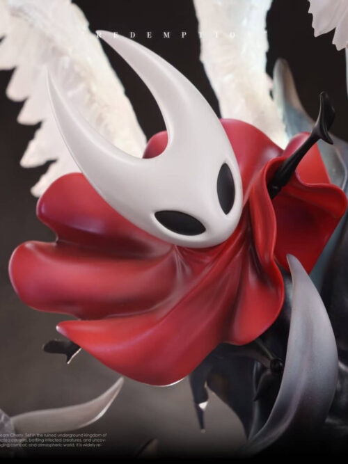 Close-up of Hornet from the Redemption statue wearing a flowing red cloak with her white horned mask and black hand reaching upward toward Lace.