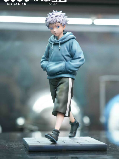 Young Satoru Gojo 1/6 scale figure wearing a blue hoodie and dark shorts walking on a rectangular paved base on a studio display surface.