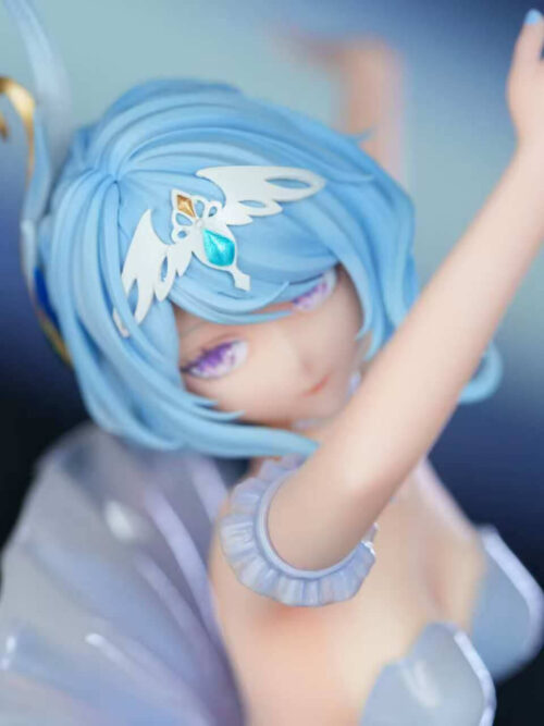 High-angle close-up of Odette Spessiva's face and light blue hair, featuring her white winged tiara with a blue gem, purple eyes, and ruffled arm band.