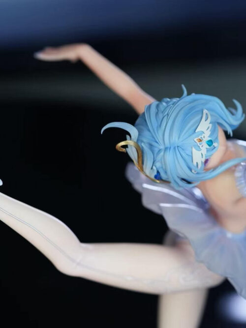 High-angle view of the Odette Spessiva figure in an arabesque pose, showing her blue hair with the winged tiara, outstretched arms, and white pointe shoe tied with ribbons.