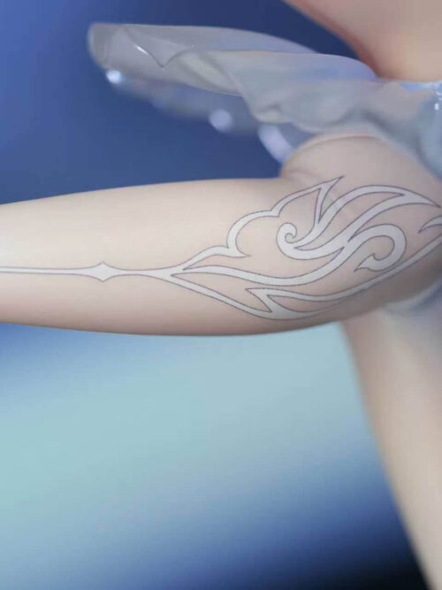 Close-up of the extended left leg on the Odette Spessiva figure showing the white stocking with silver-gray swirling patterns beneath the translucent pale blue tutu.