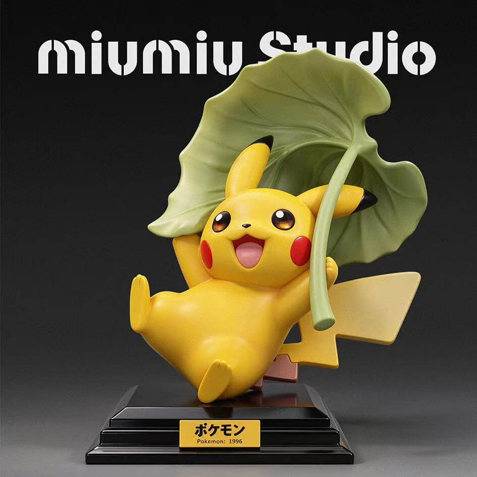 Pikachu 30th Anniversary Vol. 12 Figure Front View Front render of miumiu Studio Pikachu 30th Anniversary Vol. 12 figure holding a large green leaf above its head on a stepped black base with a Pokemon 1996 nameplate.