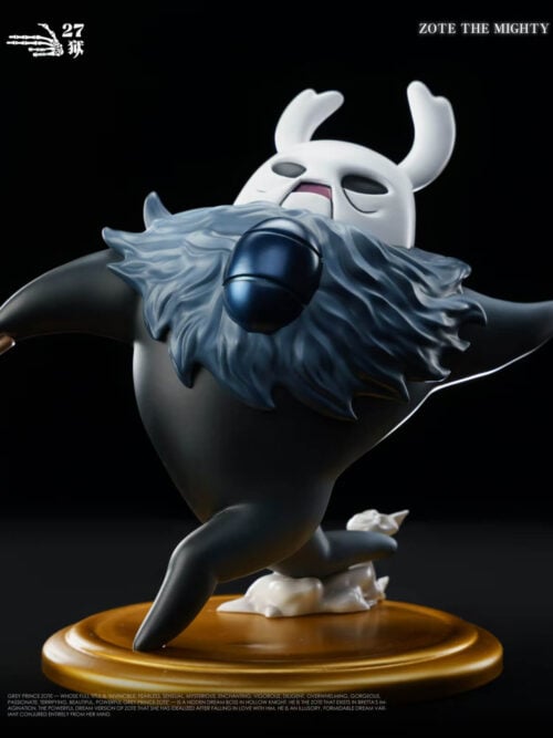 Close-up of the 27abyss Studio Zote the Mighty Grey Prince figure showing the horned white mask, shaggy blue-grey mane with dark chest emblem, and rounded black body on a gold base.