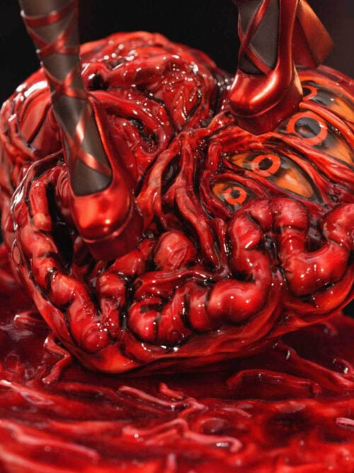 Close-up of the glossy red fleshy base with embedded orange eyes and Saya's red strapped heels on the ANNI Studio 1/6 figure.